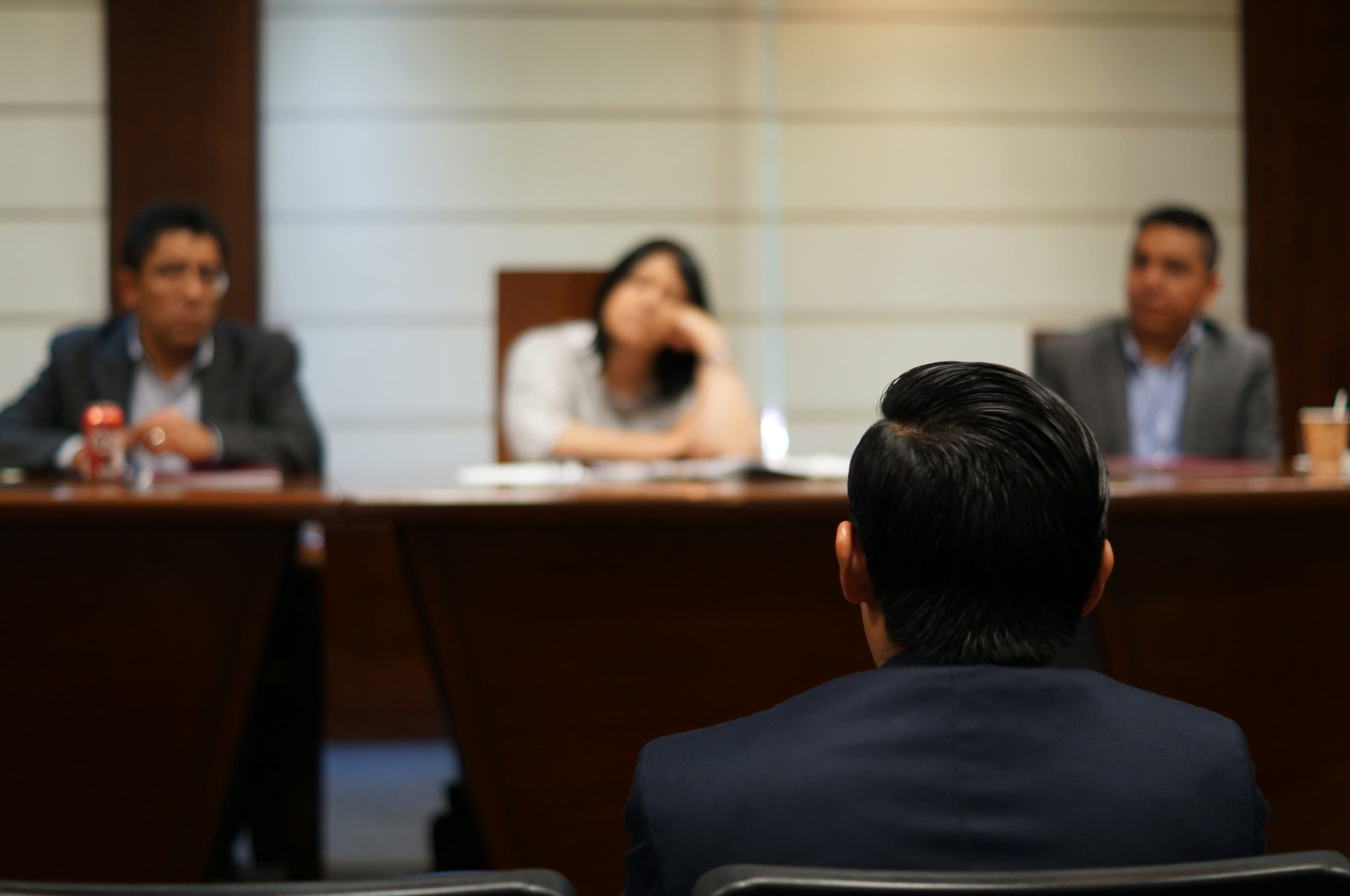 A witness giving testimony before a panel in a hearing room